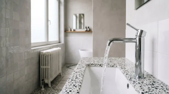 Robinetterie moderne avec filet d'eau cristallin illustrant l'optimisation du débit d'eau domestique