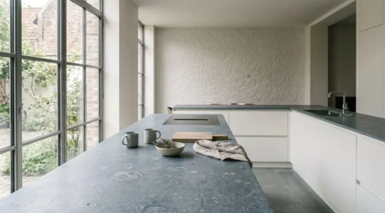 Cuisine belge moderne avec plan de travail en pierre naturelle et ambiance lumineuse