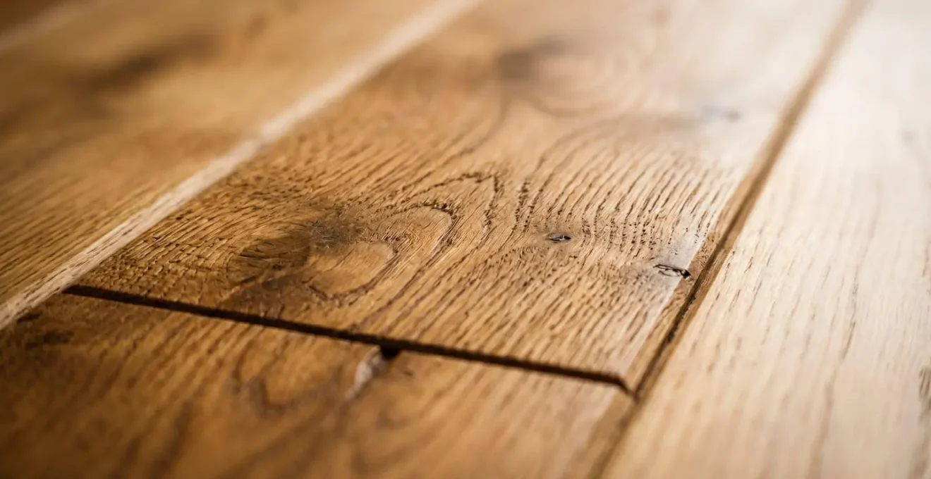 Détail photographique de lames de parquet massif en chêne avec grain naturel et finition huilée mate