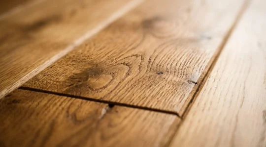 Détail photographique de lames de parquet massif en chêne avec grain naturel et finition huilée mate