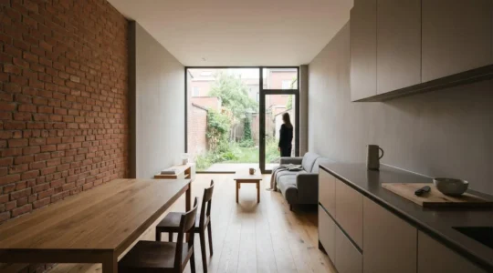 Intérieur calme d'une maison belge mitoyenne avec murs en briques, lumière naturelle apaisante et ambiance sereine illustrant le confort acoustique